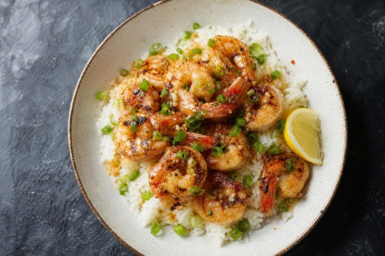 Garlic butter prawns over jasmine rice with scallions and lemon