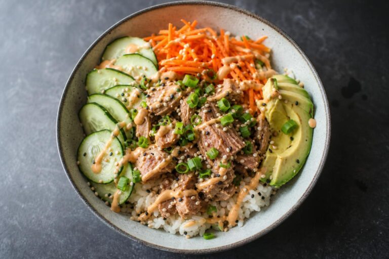 Canned tuna poke bowl with cucumber, carrot, avocado and sriracha mayo over rice