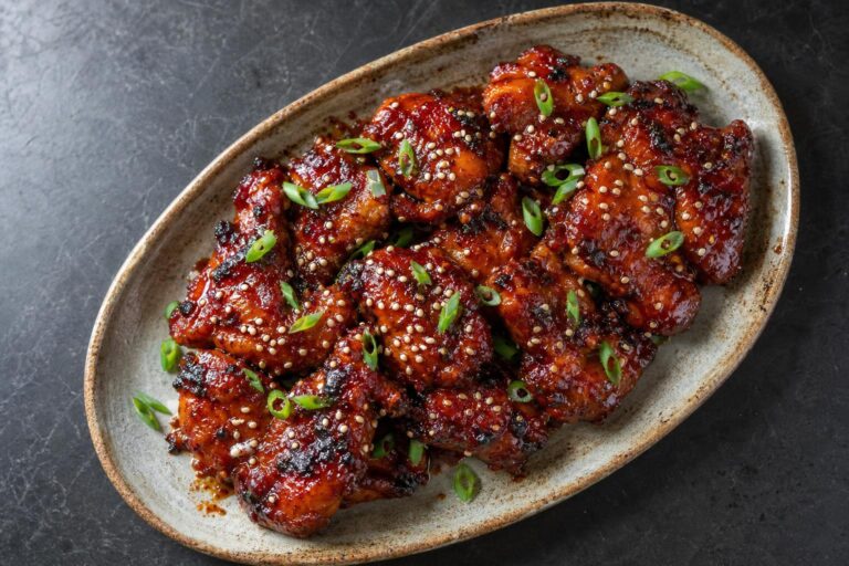 Sticky gochujang glazed chicken thighs with sesame seeds and scallions