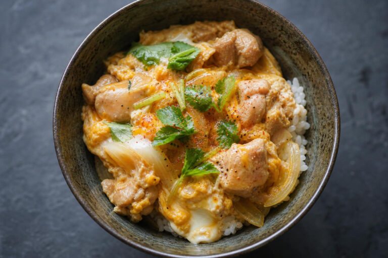 Oyakodon chicken and egg rice bowl with softly set egg and scallions