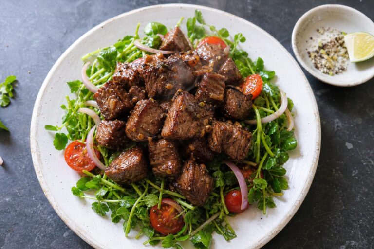 Vietnamese shaking beef (bo luc lac) with seared sirloin cubes over watercress, cherry tomatoes and red onion, with a lime pepper salt dip